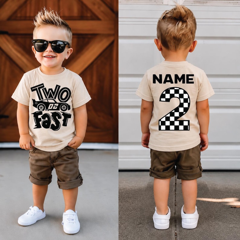 May include: A beige short-sleeved t-shirt featuring a black graphic on the front that reads TWO FAST with a race car illustration. The back of the shirt displays the word NAME above a large number 2 with a black and white checkered pattern.