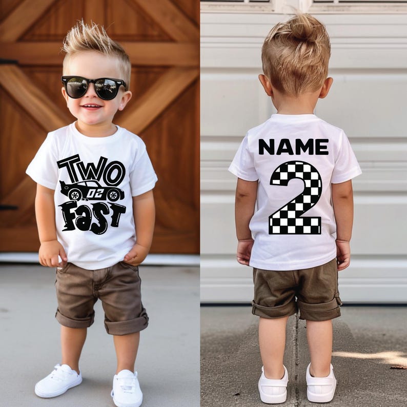 May include: A white short-sleeved t-shirt featuring a black graphic print. The front displays the text "TWO FAST" with a race car illustration. The back features the text "NAME" above a large number "2" with a black and white checkered pattern.