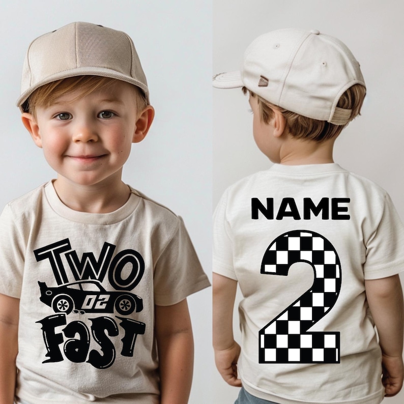 May include: A beige t-shirt featuring a black graphic of a race car with the text Two Fast on the front and the word NAME above a large checkered number 2 on the back, paired with a matching beige baseball cap worn by a young child.