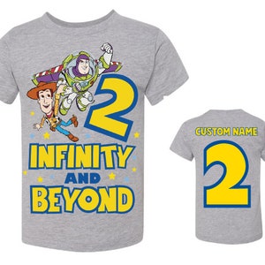 Op de afbeelding: Grijs T-shirt met een geel nummer 2, Buzz Lightyear en Woody uit Toy Story, en de tekst "Oneindig en verder".
