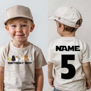 May include: A beige t-shirt with a graphic of Star Wars characters and the text "Birthday Boy". The back of the shirt has the text "NAME" and the number "5" in black.