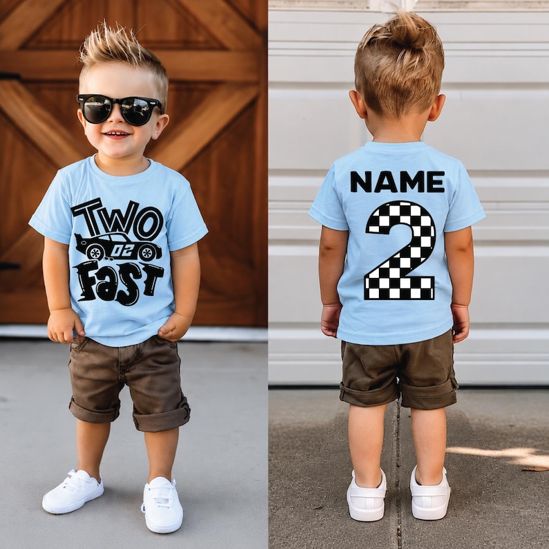 May include: A light blue t-shirt featuring a black graphic with the text Two Fast and a race car on the front, and the text NAME above a large checkered number 2 on the back. The shirt is paired with brown shorts and white sneakers.
