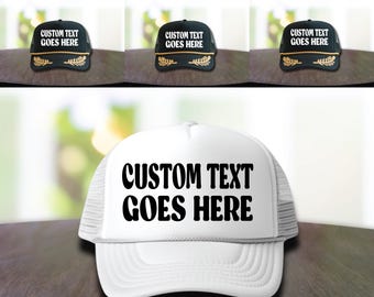 May include: White and black trucker hats with the text "CUSTOM TEXT GOES HERE" in black lettering. The hats have a mesh back and a black bill.