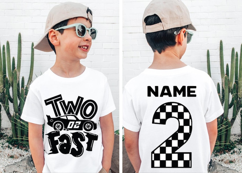 May include: A white t-shirt featuring a black graphic on the front with a race car and the text "TWO FAST". The back of the shirt displays the word "NAME" above a large number "2" with a black and white checkered pattern design.
