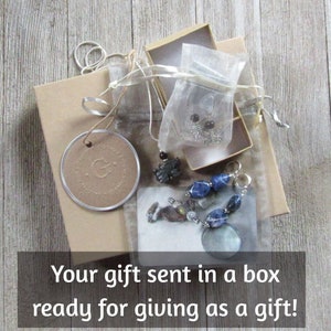 K&ouml;nnte beinhalten: Eine Geschenkbox gef&uuml;llt mit einer Halskette, Ohrringen und einem Armband. Die Box ist in braunes Papier eingewickelt und mit einer Schnur gebunden. Der Text "Your gift sent in a box ready for giving as a gift!" ist unten im Bild gedruckt.