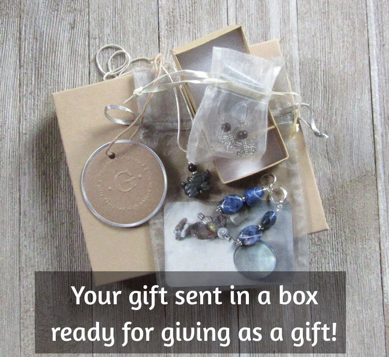 K&ouml;nnte beinhalten: Eine Geschenkbox gef&uuml;llt mit einer Halskette, Ohrringen und einem Armband. Die Box ist in braunes Papier eingewickelt und mit einer Schnur gebunden. Der Text "Your gift sent in a box ready for giving as a gift!" ist unten im Bild gedruckt.