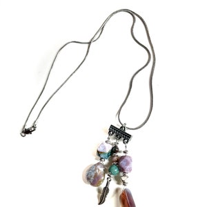 May include: A silver chain necklace with a pendant featuring a cluster of colorful agate stones, a silver feather charm, and silver beads.