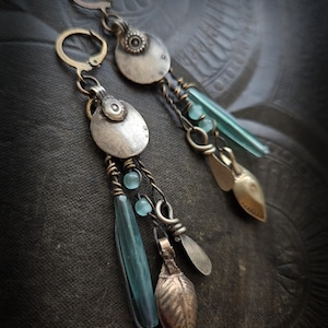 Może przedstawiać: Zestaw trzech ceramicznych kubków z nakrapianym, matowym wykończeniem. Kubki są w odcieniach kremowym, jasnoszarym i ciemnoszarym. Każdy kubek ma prosty, minimalistyczny design.