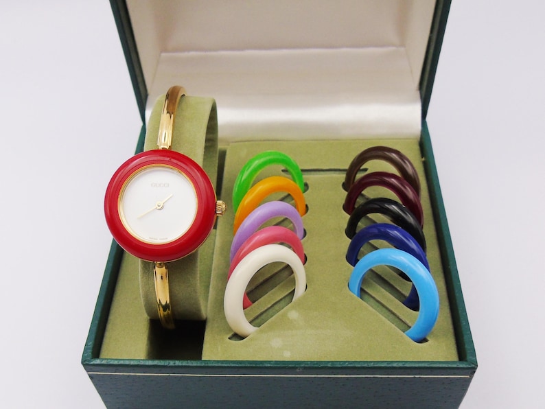 Reloj Gucci 1100L vintage de los años 90 para mujer con bisel intercambiable — Chapado en oro, cuarzo suizo, con biseles intercambiables y caja original, de segunda mano. imagen 9