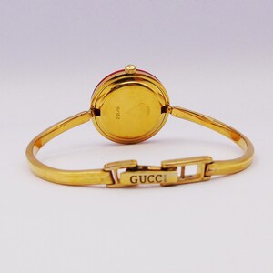 Reloj Gucci 1100L vintage de los años 90 para mujer con bisel intercambiable — Chapado en oro, cuarzo suizo, con biseles intercambiables y caja original, de segunda mano. imagen 4