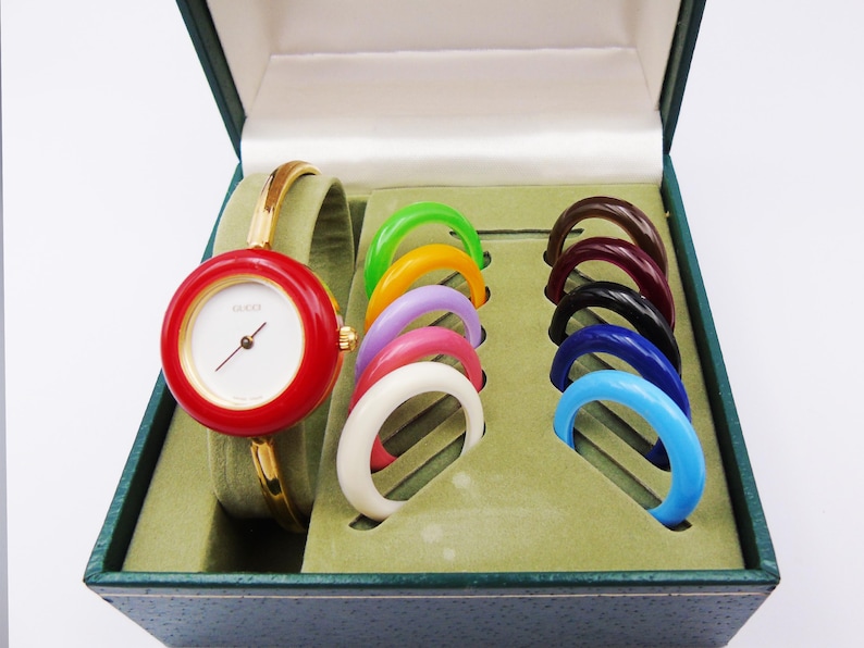 Reloj Gucci 1100L vintage de los años 90 para mujer con bisel intercambiable — Chapado en oro, cuarzo suizo, con biseles intercambiables y caja original, de segunda mano. imagen 1