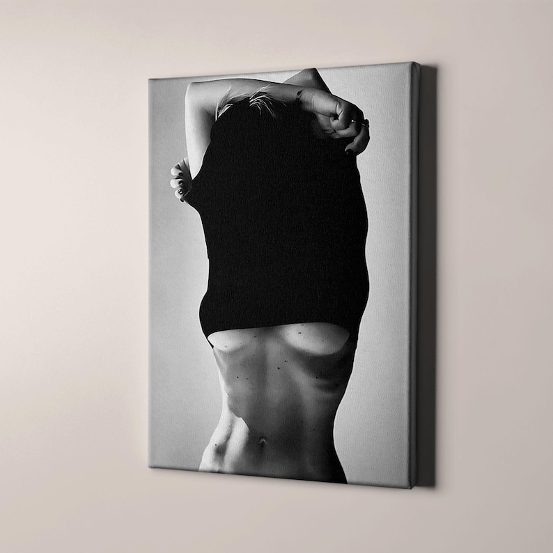 May include: A black and white photo of a person with their shirt pulled up, revealing their torso.