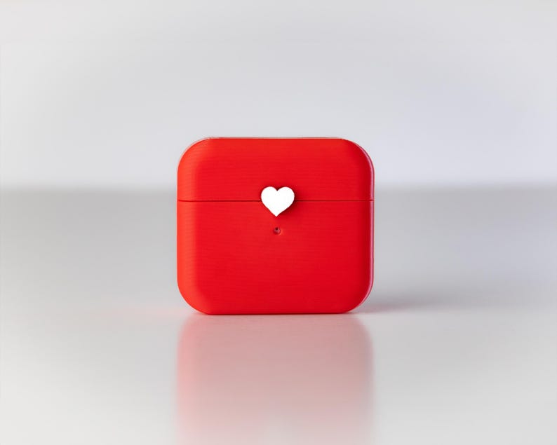 Pu&ograve; includere: Una custodia quadrata rossa con un cuore bianco in cima.