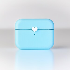 Pu&ograve; includere: Una custodia protettiva di colore azzurro per auricolari wireless con un piccolo dettaglio a forma di cuore bianco nella parte superiore.