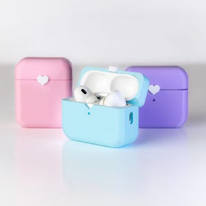 Pu&ograve; includere: Tre custodie in silicone per auricolari wireless. Le custodie sono rosa, blu e viola. Ogni custodia ha un piccolo cuore bianco sul davanti.