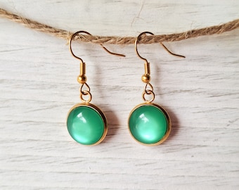 May include: A pair of gold dangle earrings with green round cabochon stones.
