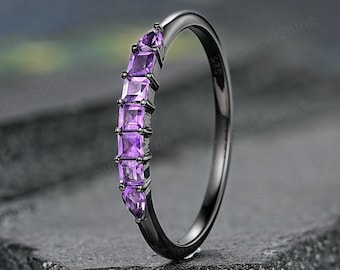 May include: A black band ring with a row of purple square-shaped gemstones.