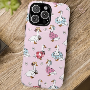Whimsical summer geese phone case featuring pastel pink background, cottagecore aesthetic, daisies, coquette vibes, floral charm, vintage-inspired design, gingham dresses, daisy lifebuoys, coconut drinks, ribbons, feminine style, nature-inspired art, dreamy pastel colors, aesthetic accessories, playful summer theme, MagSafe compatibility, trendy design, botanical whimsy, English garden feel, charming and delicate vibes, perfect for fashion-forward phone case lovers.