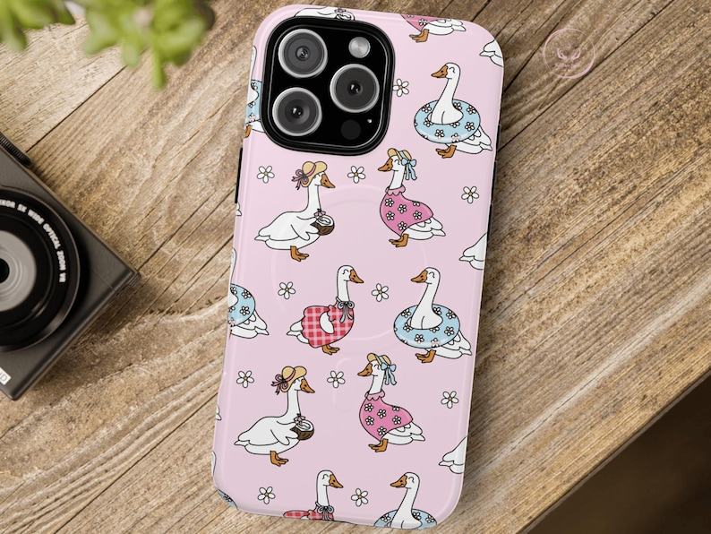 Whimsical summer geese phone case featuring pastel pink background, cottagecore aesthetic, daisies, coquette vibes, floral charm, vintage-inspired design, gingham dresses, daisy lifebuoys, coconut drinks, ribbons, feminine style, nature-inspired art, dreamy pastel colors, aesthetic accessories, playful summer theme, MagSafe compatibility, trendy design, botanical whimsy, English garden feel, charming and delicate vibes, perfect for fashion-forward phone case lovers.