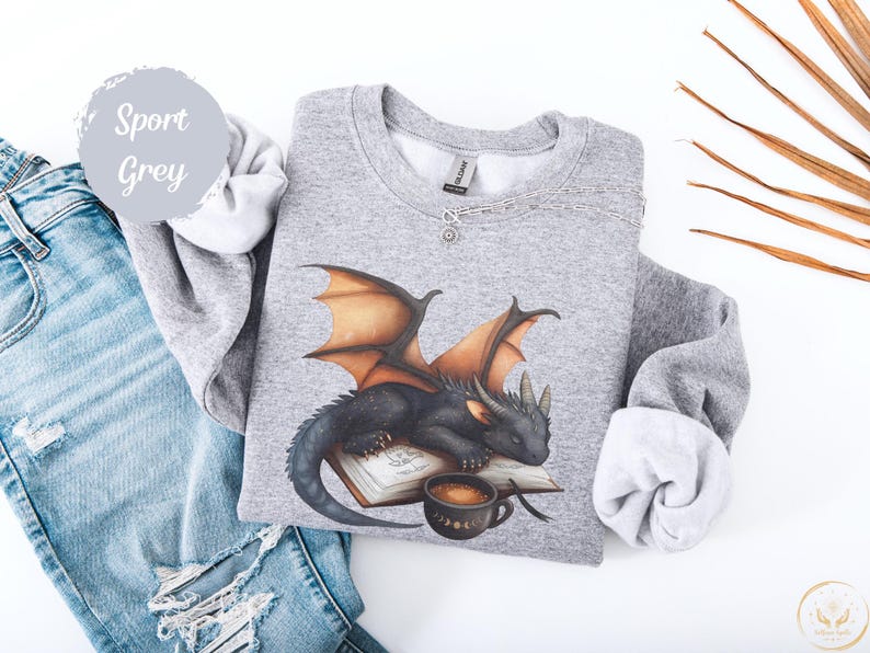 Cozy sweatshirt with cute black dragon sleeping on book on dragonkind with mug of coffee with moon phase pattern. Fourth wing Tairn Andarna dragons bookish booktok bookstagram  fantasy fan reader romantasy coffee lover gift idea soft warm sweater GOT