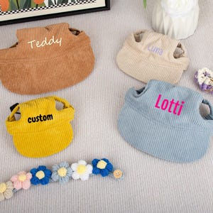 Pu&ograve; includere: Quattro pettorine per animali domestici in velluto a coste marrone, beige, giallo e blu, ciascuna con un nome ricamato sul davanti. Sono inclusi anche un collare e un braccialetto floreale abbinati. Le pettorine sono progettate per cani o gatti di piccola taglia.