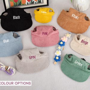 Pu&ograve; includere: Una collezione di cappelli per animali domestici in velluto a coste in vari colori, tra cui nero, giallo, kaki, rosa, blu, grigio, beige e verde. Ogni cappello ha un'etichetta con il nome del colore. Sono presenti anche un accessorio floreale per capelli e un guinzaglio.
