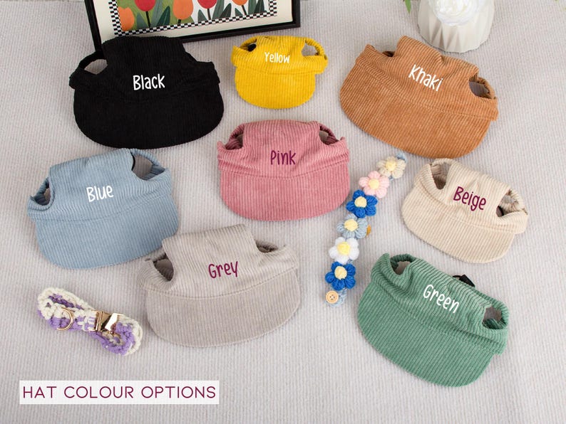 Pu&ograve; includere: Una collezione di cappelli per animali domestici in velluto a coste in vari colori, tra cui nero, giallo, kaki, rosa, blu, grigio, beige e verde. Ogni cappello ha un'etichetta con il nome del colore. Sono presenti anche un accessorio floreale per capelli e un guinzaglio.