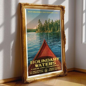 Peut inclure: Une affiche encadr&eacute;e montrant un cano&euml; rouge sur une eau bleue avec une for&ecirc;t en arri&egrave;re-plan. Le texte indique : ESTABLISHED SEPTEMBER 3, 1964, BOUNDARY WATERS CANOE AREA WILDERNESS, U.S. DEPARTMENT OF AGRICULTURE, UNITED STATES FOREST SERVICE.