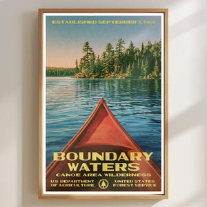 Peut inclure: Une affiche encadr&eacute;e montrant un cano&euml; rouge sur une eau bleue face &agrave; une for&ecirc;t. Le texte indique : ESTABLISHED SEPTEMBER 3, 1964, BOUNDARY WATERS CANOE AREA WILDERNESS, U.S. DEPARTMENT OF AGRICULTURE, UNITED STATES FOREST SERVICE, avec un logo d'arbre.