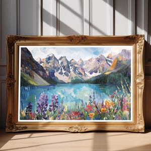 May include: An oil painting of a mountain lake scene, framed in a gold ornate frame. The artwork depicts a blue lake with mountains in the background and colorful wildflowers in the foreground. The painting is displayed on a wooden surface.