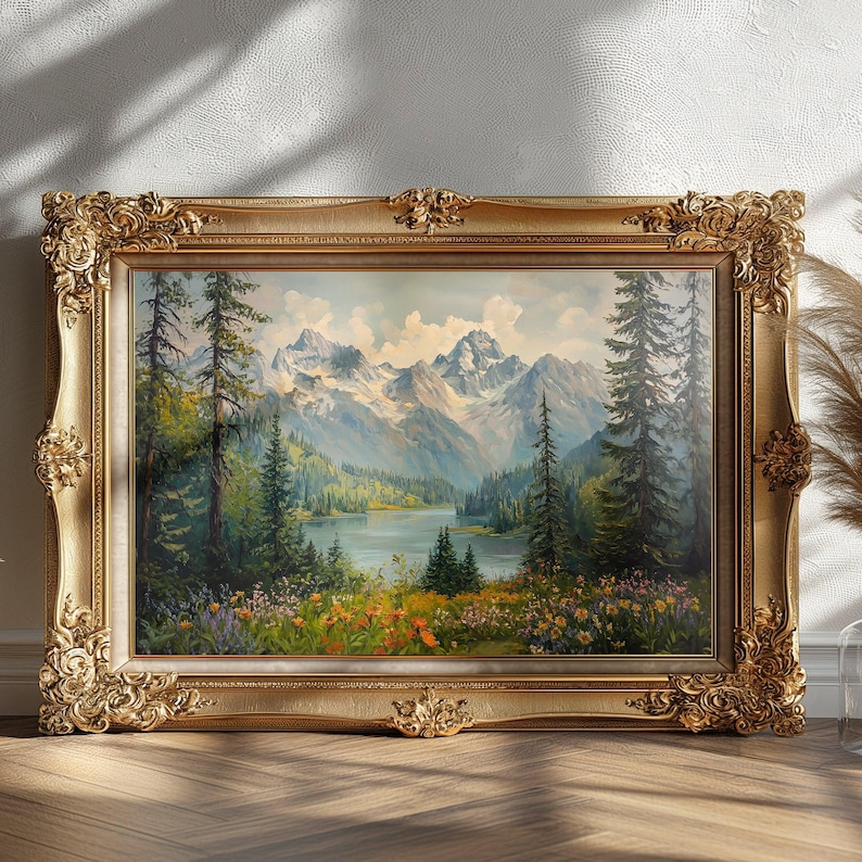 Pu&ograve; includere: Un dipinto di paesaggio incorniciato che rappresenta una catena montuosa con un lago in primo piano. Le montagne sono innevate e il lago &egrave; circondato da alberi. Il dipinto &egrave; in una cornice dorata.