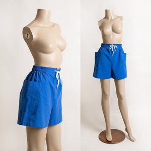 May include: Blue denim shorts with white drawstring ties and side pockets.