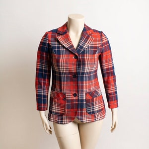 May include: A red and blue plaid blazer with a three-button closure. The blazer has two flap pockets on the front.