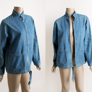May include: A blue denim jacket with a zipper closure and a tie at the waist.