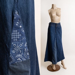 May include: A long denim skirt with a patchwork design on the front. The skirt has a high waist and a flared silhouette.