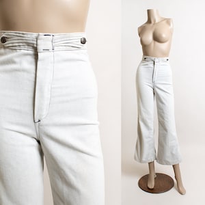 May include: A pair of white high-waisted wide-leg pants with a button fly and a wide, flared leg.
