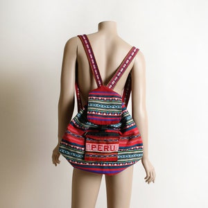 May include: Red, blue, and green patterned backpack with a smaller pocket on the front that says "PERU".