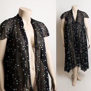 May include: A sheer black robe with a white star pattern. The robe has a V-neckline and short sleeves.