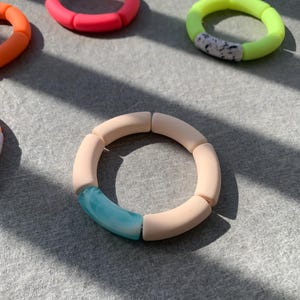 Pode incluir: Um conjunto de pulseiras de silicone coloridas com um design único. Cada pulseira é feita de várias peças de silicone, criando um visual robusto e moderno. As pulseiras estão disponíveis em uma variedade de cores, incluindo rosa, verde e bege.