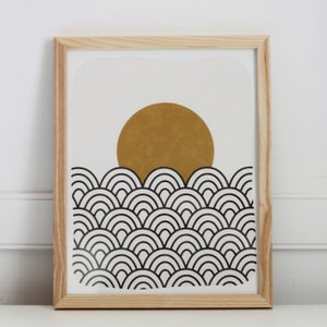 May include: A framed print with a black and white geometric pattern of overlapping semi-circles. A large, gold circle sits on top of the pattern.