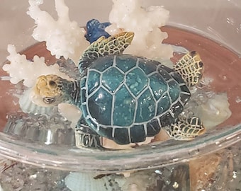 Expires Feb 19, 2022 Sea Turtle swimming alongside White Coral in Aqua Water inside Cocktail Glass