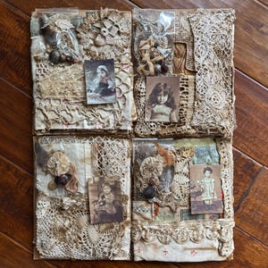 May include: Four square fabric collages featuring beige and cream lace, crochet doilies, and vintage-style photographs of children. Each section includes small plastic bags containing assorted buttons, ribbons, and textile embellishments.
