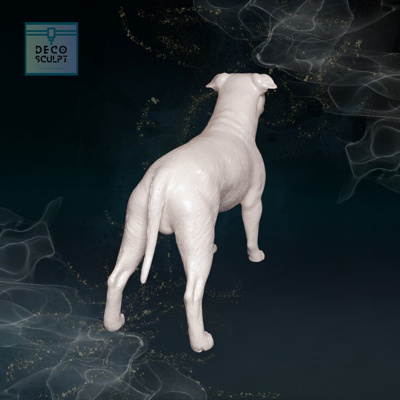 May include: White ceramic sculpture of a dog standing on a dark background. The dog is facing away from the camera and has its tail curled up.