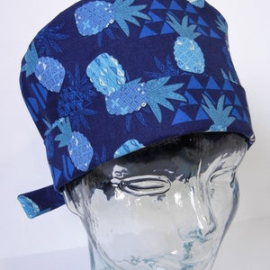 May include: A blue surgical scrub hat with a pineapple and triangle pattern.