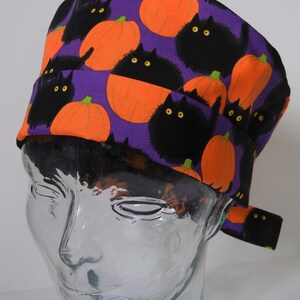 Pode incluir: Chapéu de trabalho roxo com estampa de Halloween de gatos pretos e abóboras laranja.