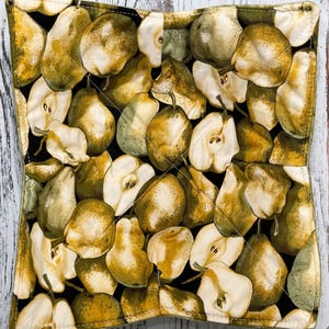 May include: Square quilted pot holder with a black background and a pattern of pears in shades of green, yellow, and brown. The pears are whole and sliced, with visible stems. The edges are finished with a yellow border.