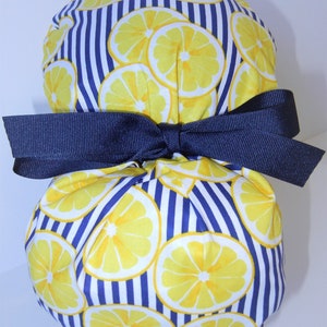 May include: A blue and white striped fabric pouch with a yellow lemon print. The pouch is tied with a navy blue ribbon.