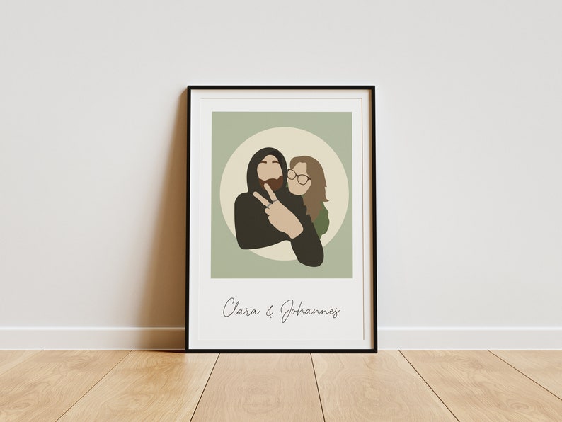 May include: A framed illustration of a couple, a man and a woman, in a circle on a green background. The man is wearing a black hoodie and has a beard. The woman is wearing glasses and a green shirt. The text "Clara & Johannes" is below the illustration.