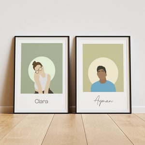 May include: Two framed illustrations of people, one with a woman with brown hair wearing glasses and a white shirt, and the other with a man with brown skin wearing a blue shirt. The woman's illustration is labelled "Clara" and the man's illustration is labelled "Ayman".