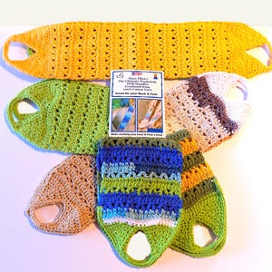 May include: A set of six crocheted washcloths in various colors, including yellow, green, brown, blue, and white. The washcloths have handles and are made from 100% cotton yarn. The text on the card reads "Mary Ellen's The Ultimate Washcloth With Handles Crocheted from 100% Cotton Yarn Great for your Back & Feet Make washing your back & Feet a treat"